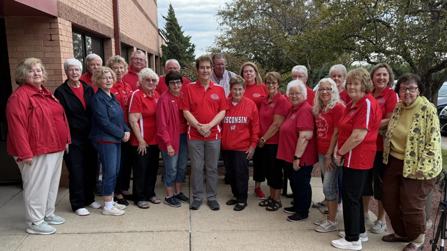 WEAC Retired board of directors in front of the WEAC buidling all wearing red shirts