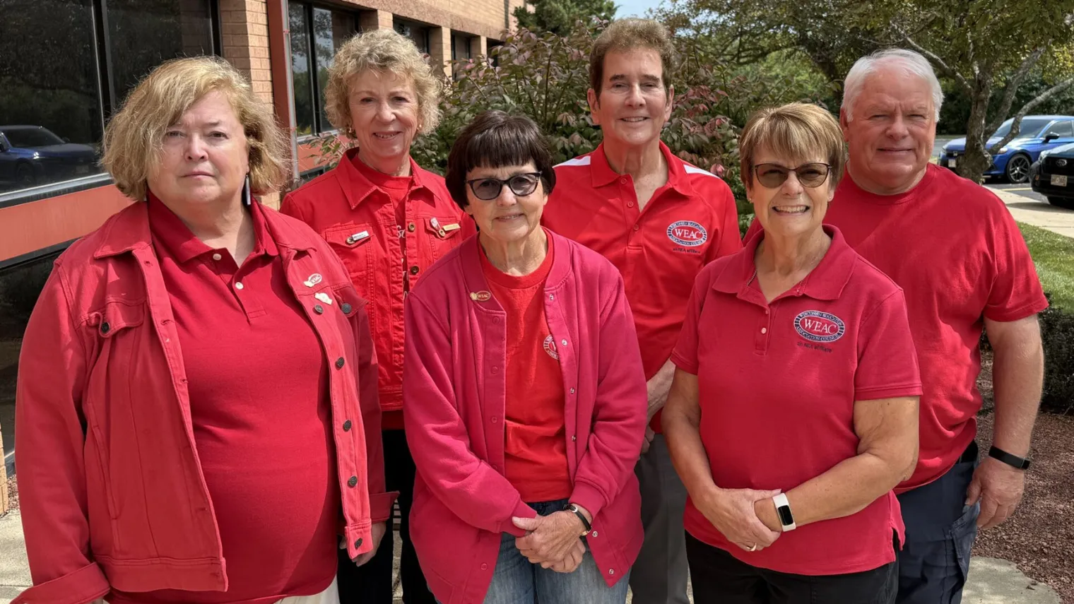 WEAC Retired executive committee members standing in a group all wearing red shirts