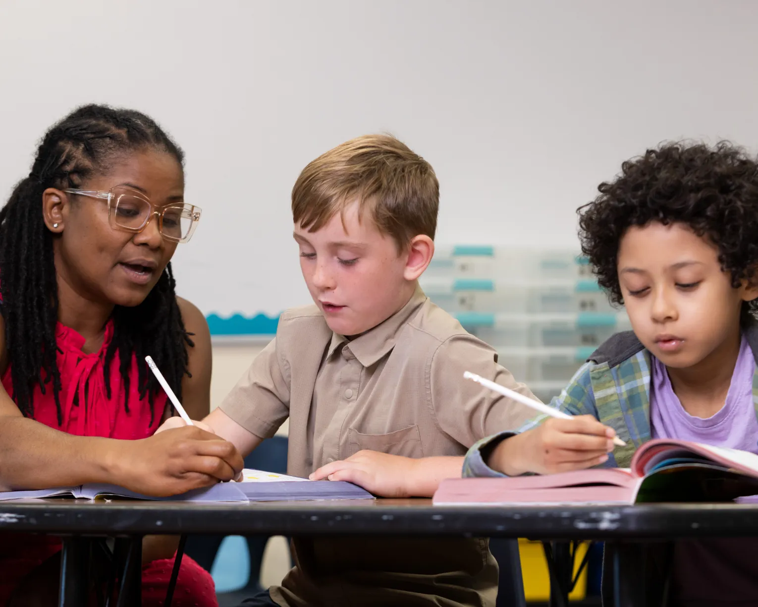 Teacher helping two students with school work