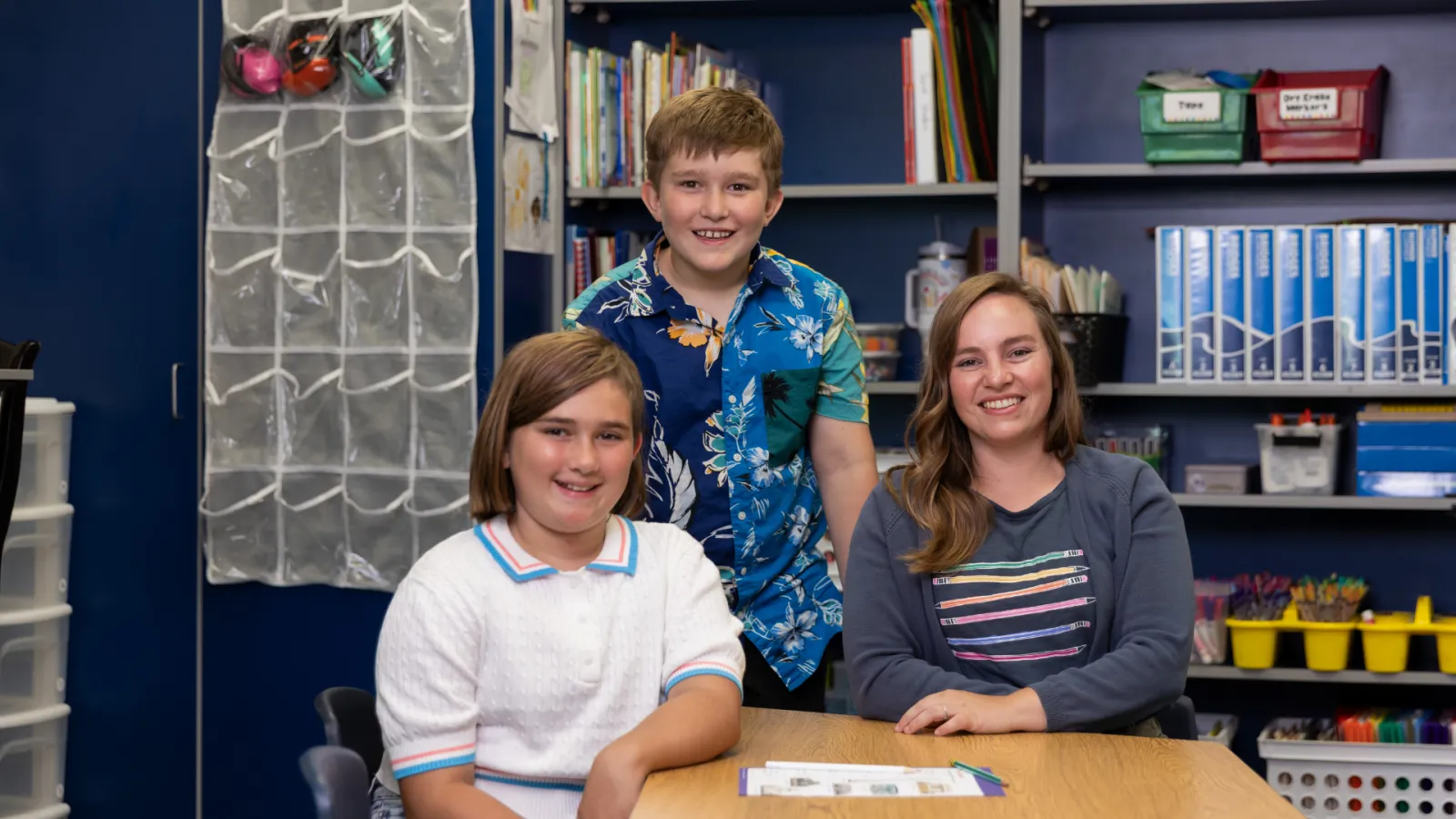 Teacher with students in classroom posing for the camera