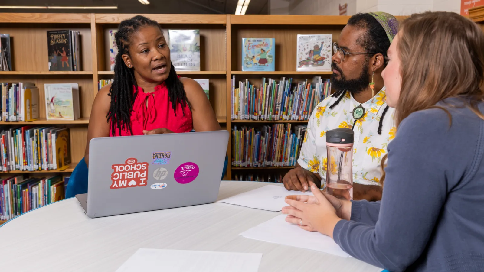 Educators collaborating at a table in a library.