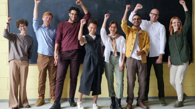 Group of intructors celebrating in front of a chalk board