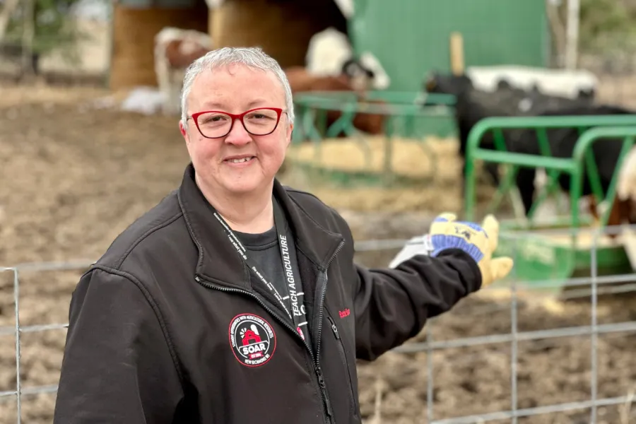 Member standing in front of farm